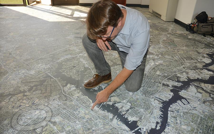 Person pointing at a map on the floor