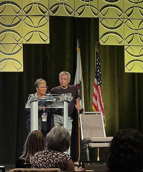 Two people at podium on stage