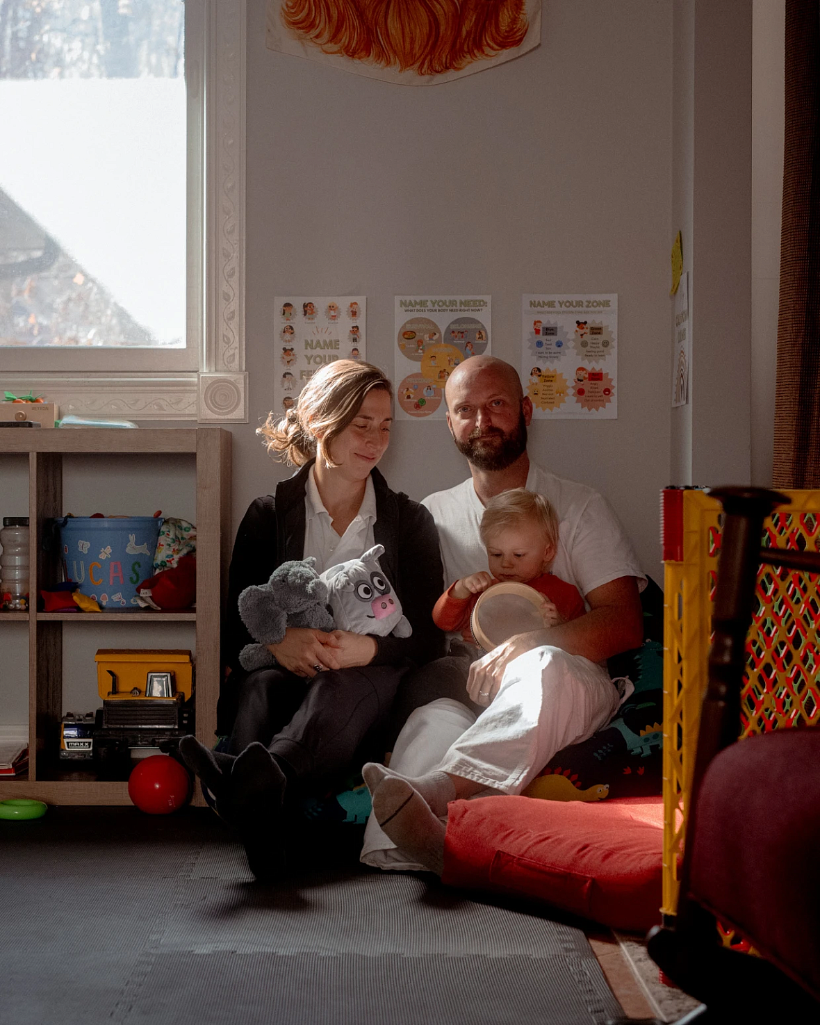 2 people sitting together, one with a child in their lap