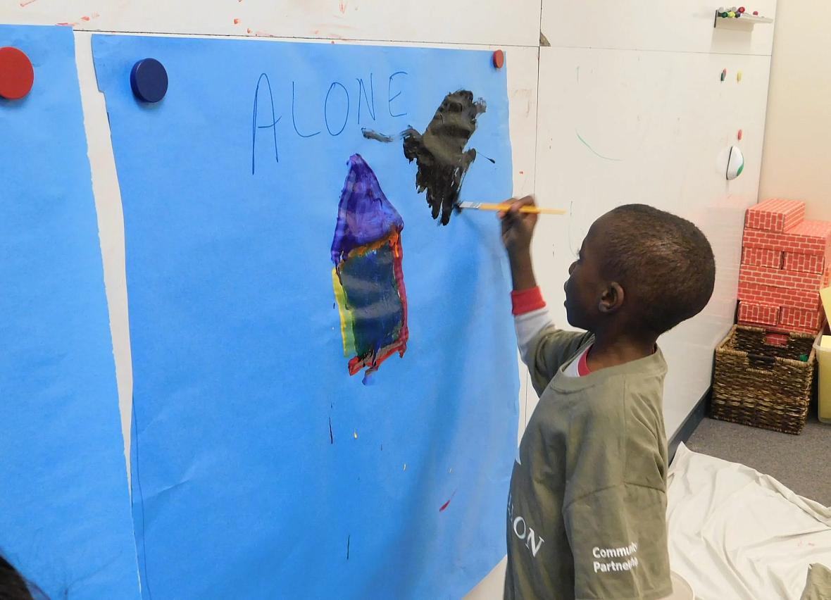 Child painting on blue paper