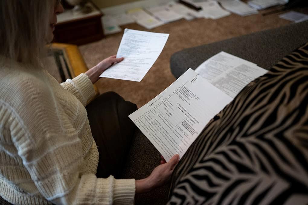 Elaine Sheffer, in her home in Sacramento, reviews paperwork related to her stepdaughter, a nonverbal autistic woman who receives services from one of California's 21 regional centers that serve people with developmental disabilities.