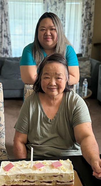 Two people behind a table with a cake on it