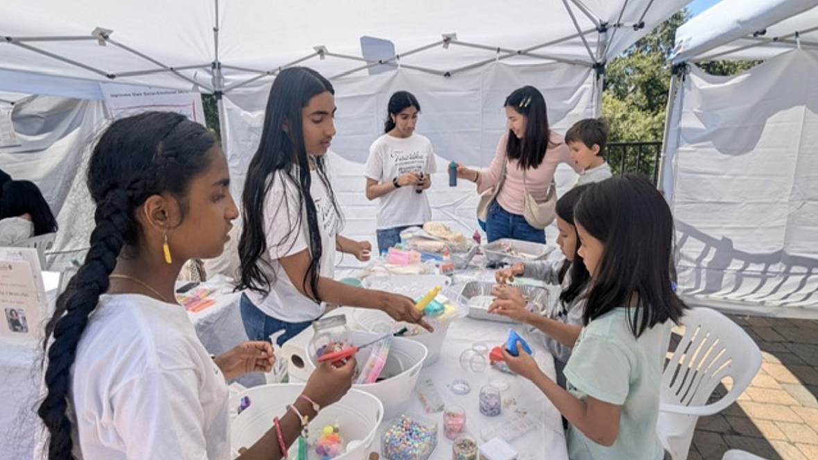 Young Desi youth volunteers work with children on an art project
