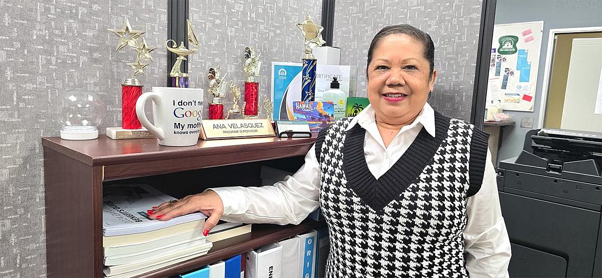 A woman stands in her office