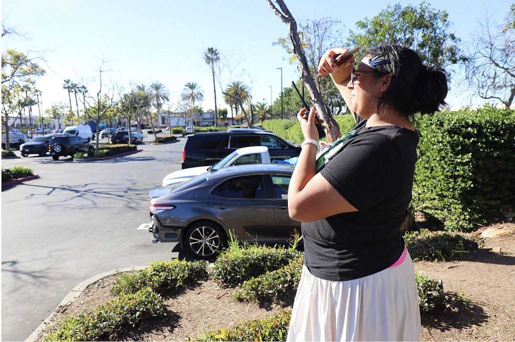 Celeste, a Santa Ana hub member, scans the Home Depot parking lot after receiving a call of a raid nearby. 
