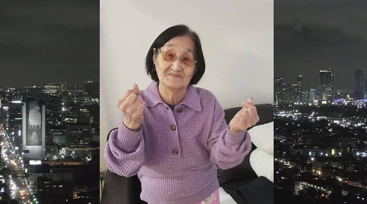 a 97-year-old Korean American woman wears a purple sweater