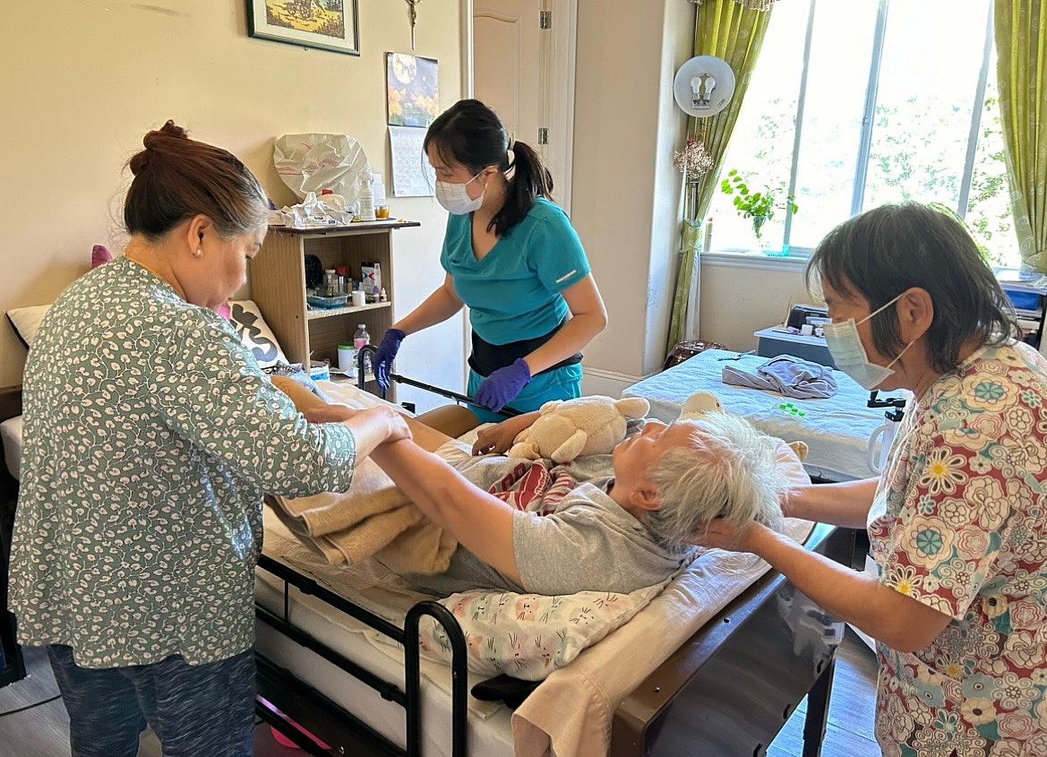 3 people assisting an elderly person