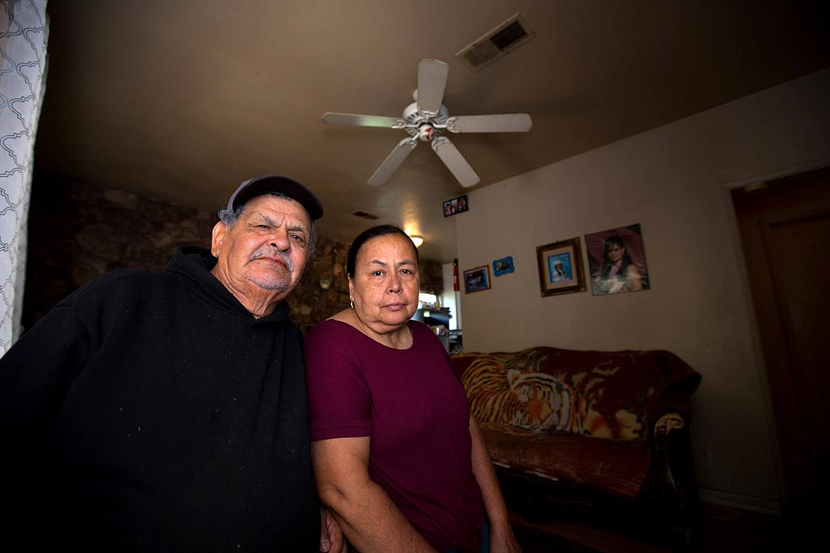 A man and a woman posing for a camera in a room