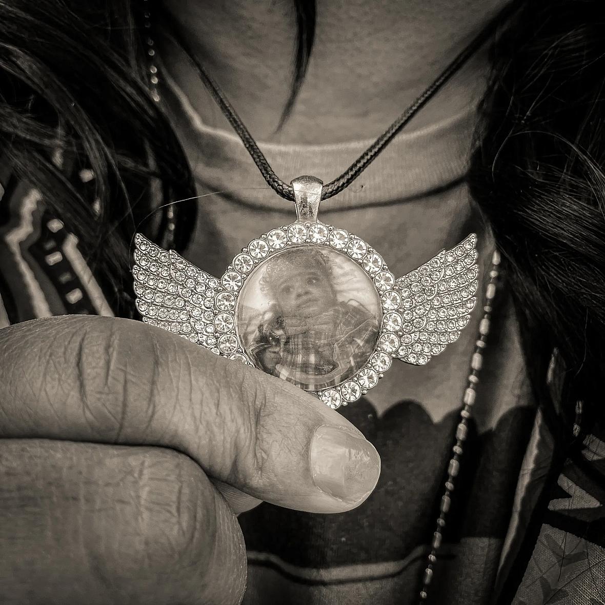 Image of a person showing their pendant