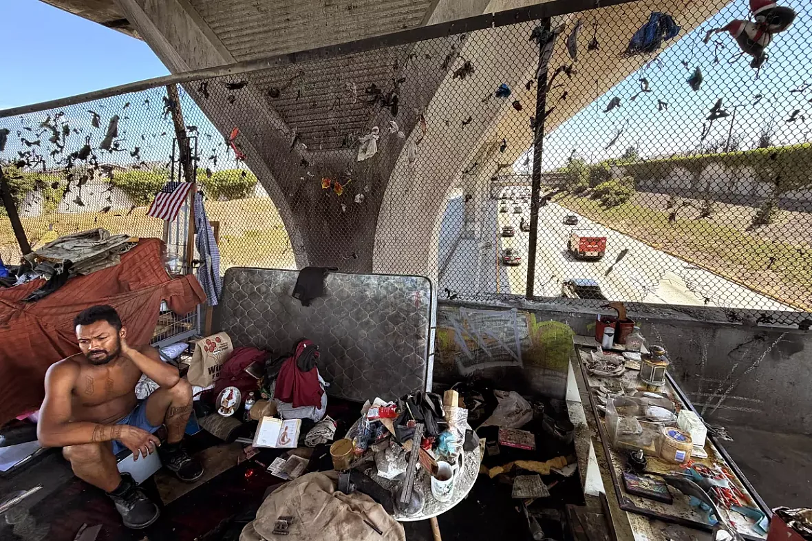 A men sits at a row of encampments