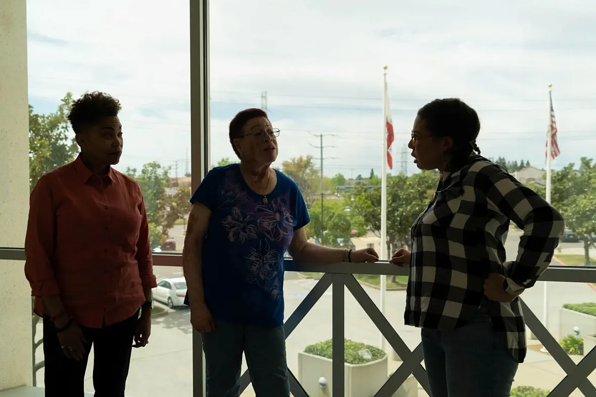 Three people standing over a balcony