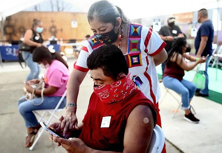 Image of a person in mask looking at phone