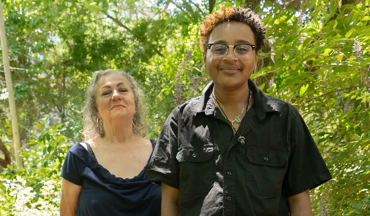 Two people standing next to each other in greenary
