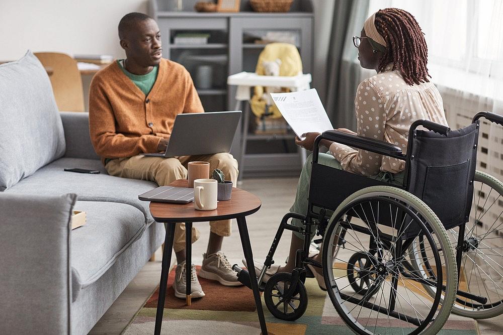 2 people conversing, one in a wheelchair