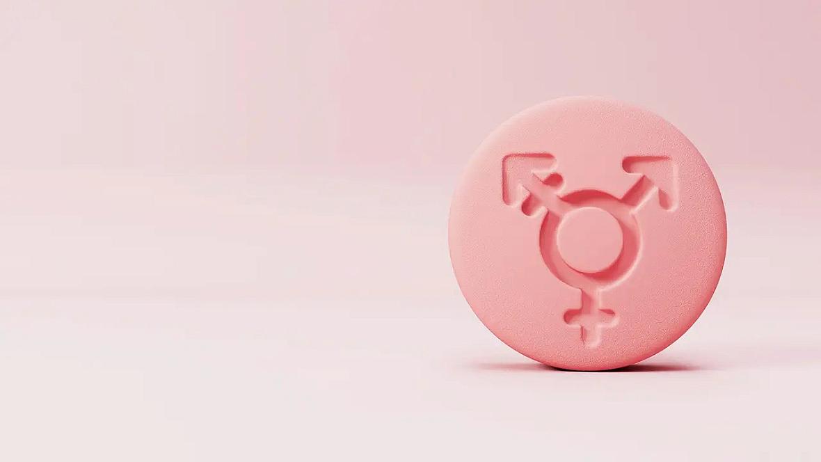 Pink pill with gender symbols on it