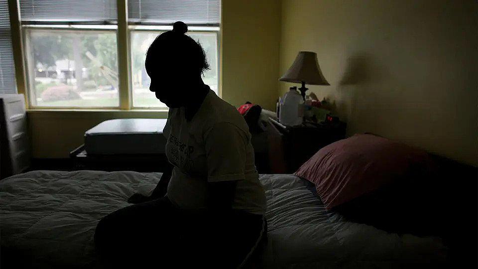 Woman sitting on her bed in a room