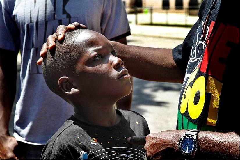 An adult consoling a child by stroking their head