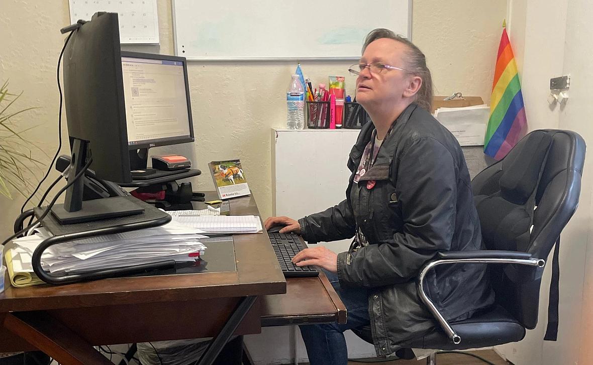 Person sitting on chair looking at a monitor and working