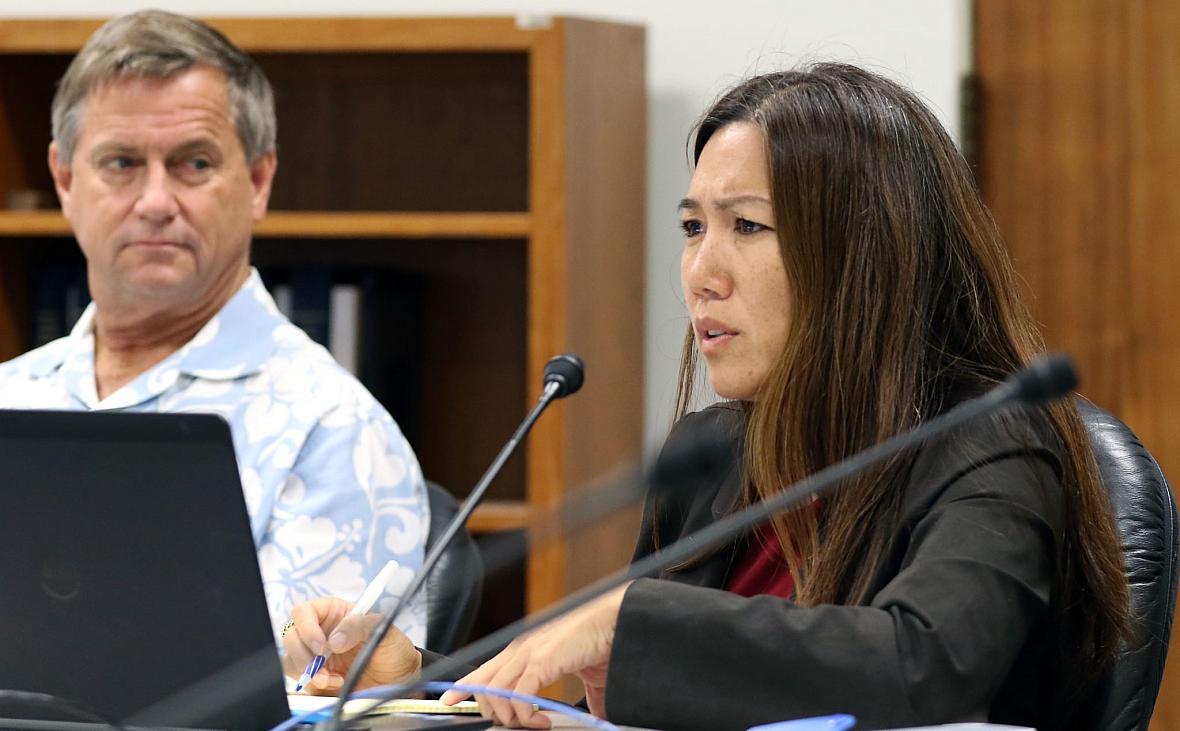 A woman listening in budget conference and man on her left listening her