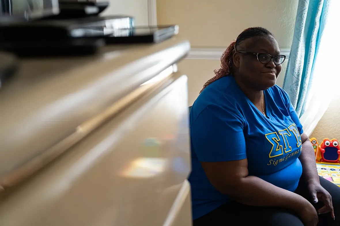 Person in blue top sitting in a room