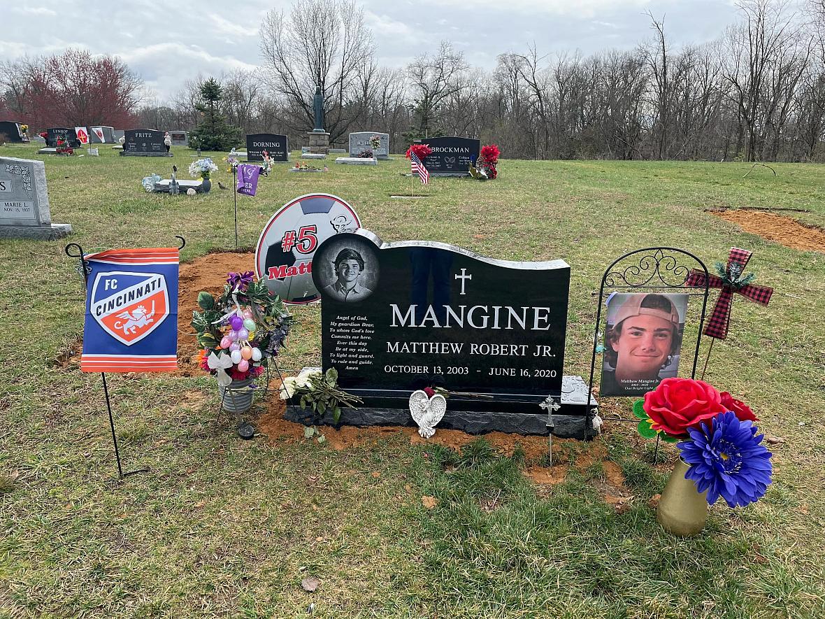 Grave of a player with his school's football fc flag and bouquet of flowers
