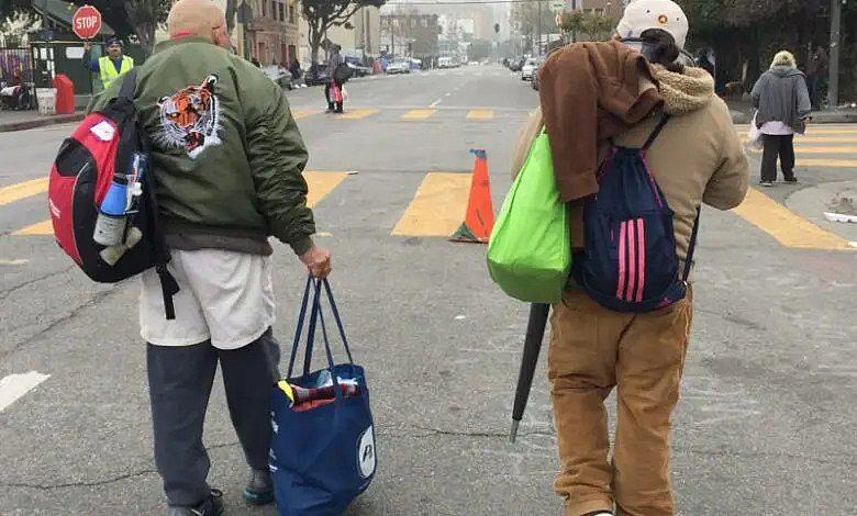 Two people walking on a street with their bags