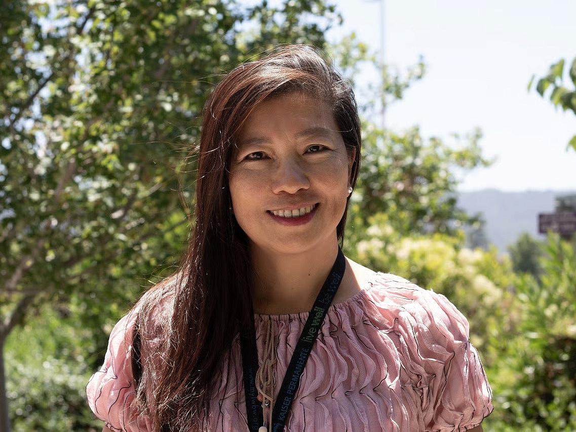 Person in pink top standing outdoors