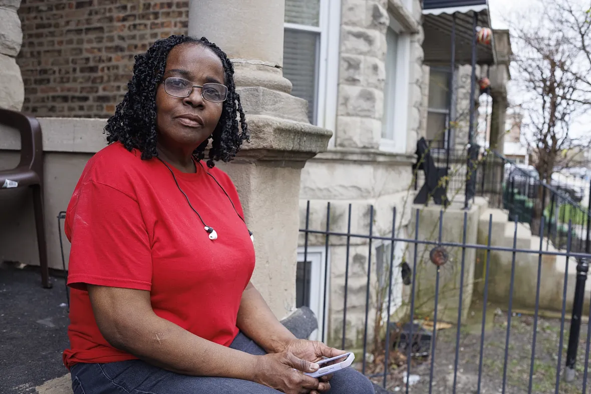 A women sitting by a house 