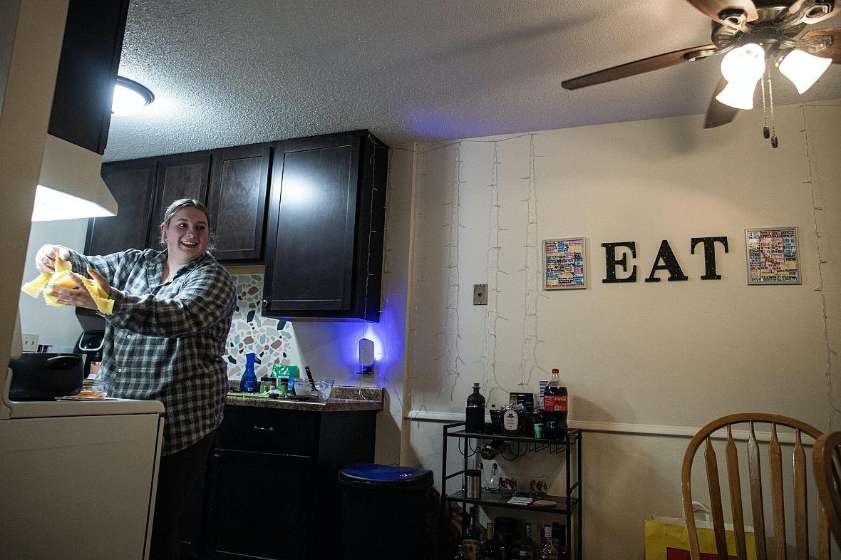 Woman standing in kitchen cooking food.