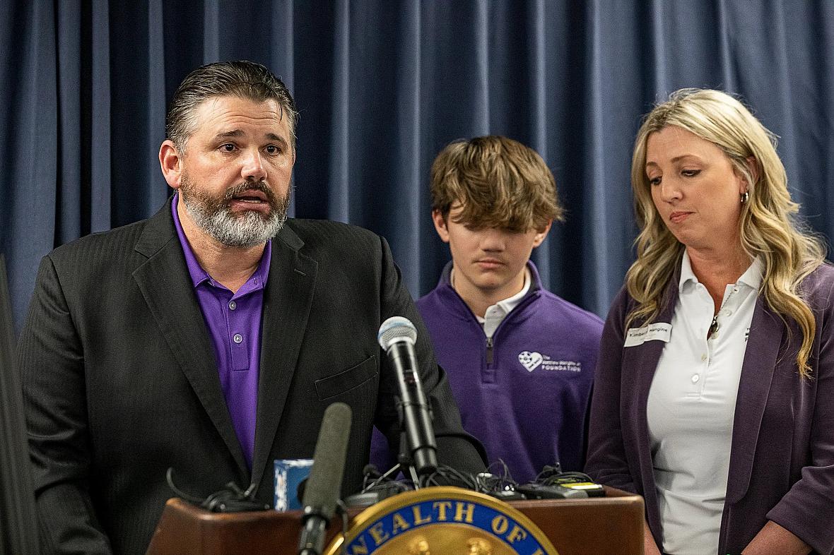 Man delivering speech with his son and wife.