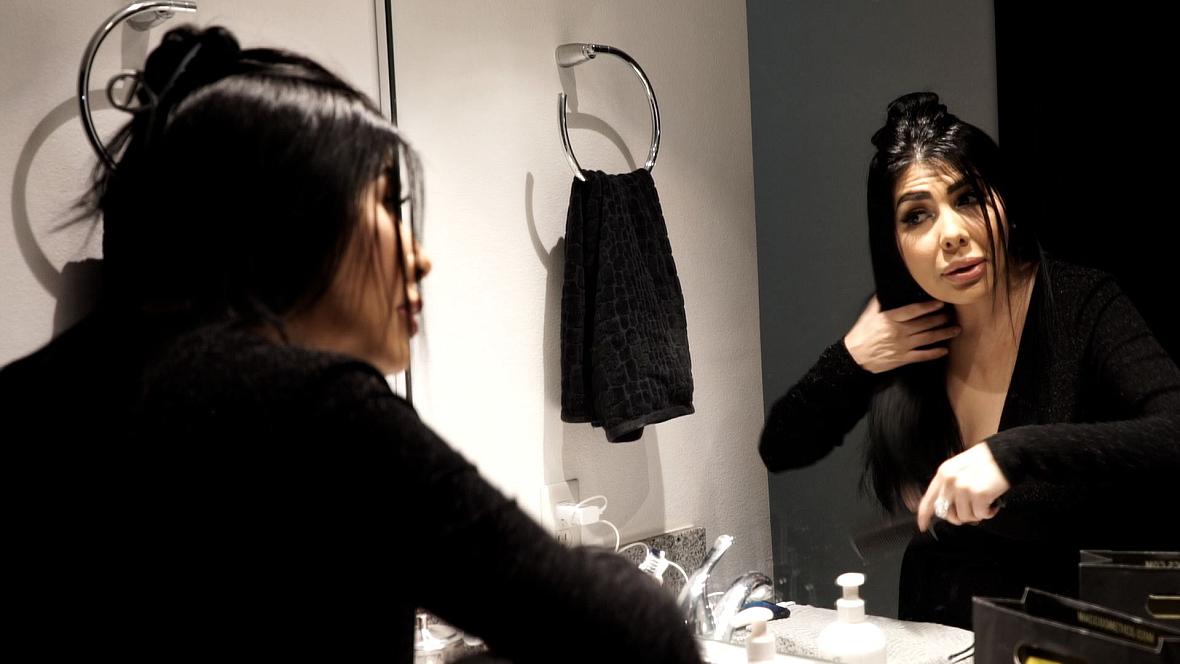 Person doing makeup in front of a mirror