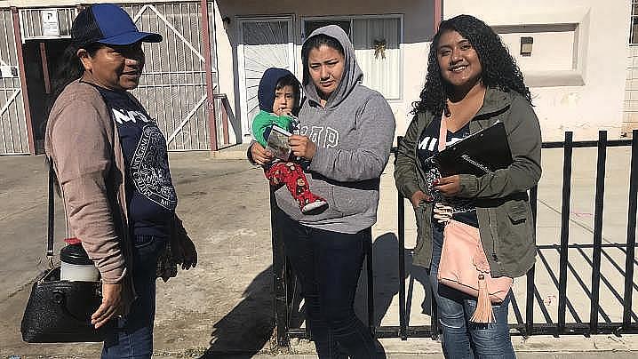 Tres mujeres de pie juntas con un bebé.