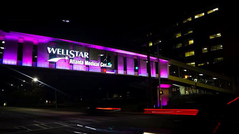 Image of a Wellstar hospital in night with purple lights on name