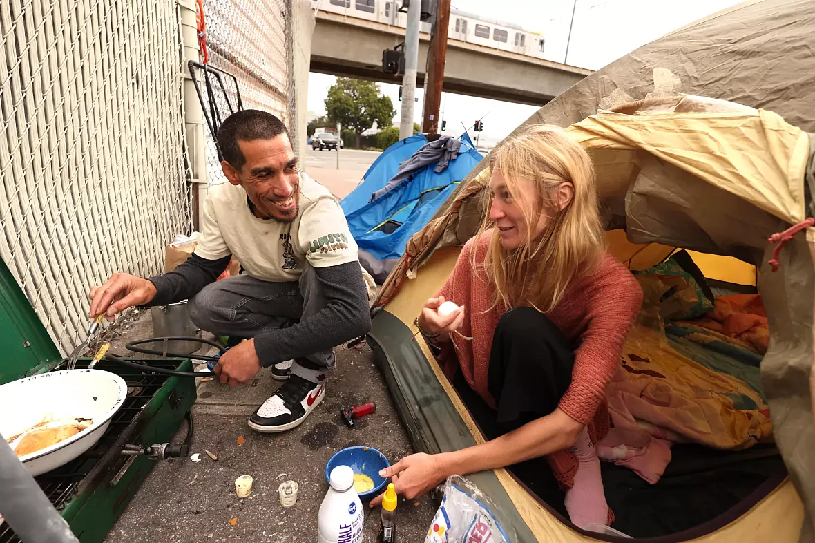 Two people preparing breakfast on street
