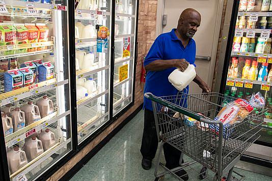 A customer buys a gallon of milk in the Cash Saver grocery store on Wilson Avenue. Sept. 25, 2018