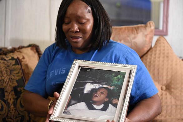 Jessie Evans becomes emotional as she holds a portrait of her son, Cornelius James Evans, taken when he was 5 years old, at her home in Donalsonville, Ga. JON-MICHAEL SULLIVAN/STAFF
