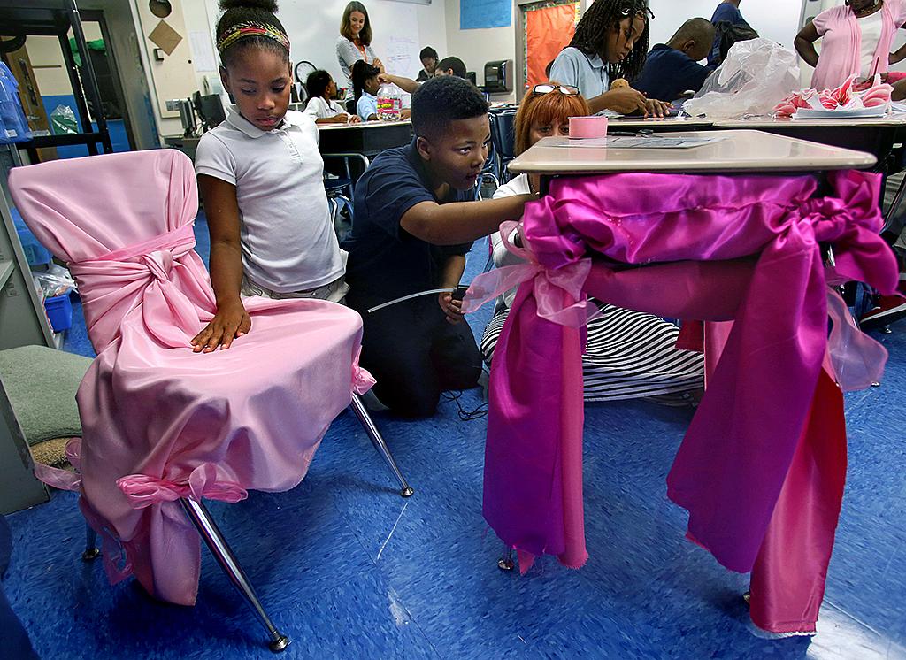 Fourth-grade classmates Rayell Hickman (left) and Kendal Bolden decorate the desk of his sister Jamyla Bolden at Koch Elementary School in September. Jamyla was killed in a drive-by shooting on Aug. 20, 2015, while doing her homework inside her mother’s bedroom.