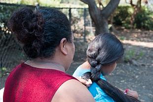 Victoria braids her daughter's hair after taking a shower at Hope's Corner. Photo by Ana Sofia Amieva-Wang