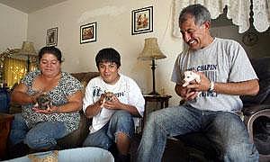 Calixto Orantes, right, his son Julio, 17, center, and wife Edel, left, play with their new puppies at their home. Calixto Orantes, right, his son Julio, 17, center, and wife Edel, left, play with their new puppies at their home.