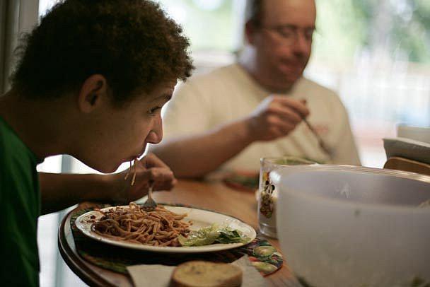 Ryan Treece, 13, gobbles down dinner - as well as regular doses of junk food - but it doesn't seem to affect his weight. His twi