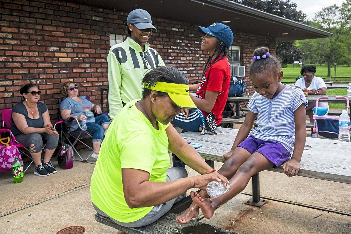 Yolanda Wade, left, washes the feet of Savanna Wiggins, 5, during a family outing with McKeesport Family Center, Friday, May 31,