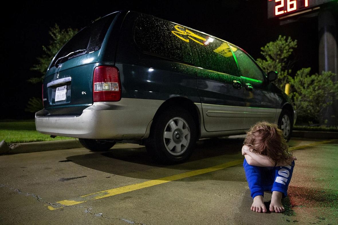 In a Victoria motel parking lot, Zoey Bowman sits on the ground and pouts in front of her mother's minivan in September. The 5-y