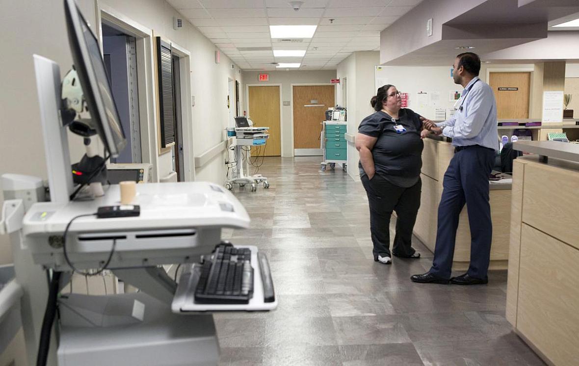 Registered nurse Amanda Day and Dr. Aswani Suthrave confer at the nurses' station.