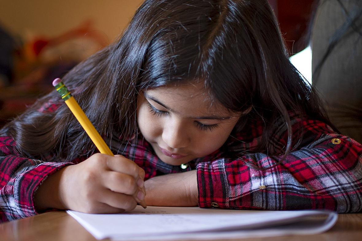 Fernanda Davila works on a spelling packet at the kitchen table in her Phoenix home on March 8, 2022.