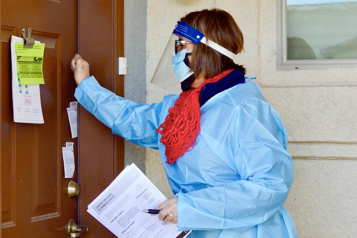 Rosa Guerra, coordinator of Promotoras de Salud of Campesinos Sin Fronteras, knocks on the door of an apartment in San Luis, Ariz., to offer COVID-19 testing on Friday, Jan. 15, 2021. Senior population was the main target of Fridays' testing during the ASU and Equality Health Foundation pilot program. Free saliva tests engineered by Arizona State University's Biodesign Institute are administered in Yuma County's small border city of San Luis to disabled and older people living in subsidized housing. The tests have also been given to hundreds of farmworkers. Rosa Guerra, coordinator of Promotoras de Salud of Campesinos Sin Fronteras, knocks on the door of an apartment in San Luis, Ari