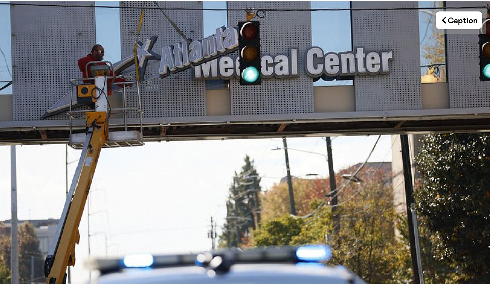 Crew members work removing the signs out of the bridge from the Atlanta Medical Center on Tuesday, November 1, 2022. The doors t