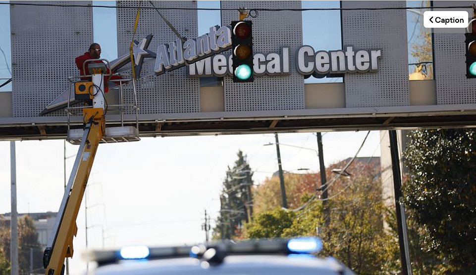 Crew members work removing the signs out of the bridge from the Atlanta Medical Center on Tuesday, November 1, 2022. The doors to Atlanta Medical Center downtown will be locked at midnight. Crew members work removing the signs out of the bridge from the Atlanta Medical Center on Tuesday, November 1, 2022. The doors t