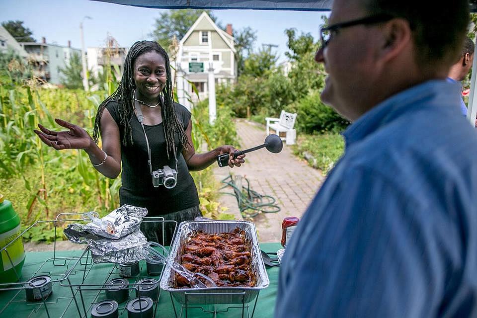 Jhana Senxian, left, founder of the Coleman Street Neighbors Association, served food in the community garden during a block party in September. ARAM BOGHOSIAN FOR THE BOSTON GLOBE