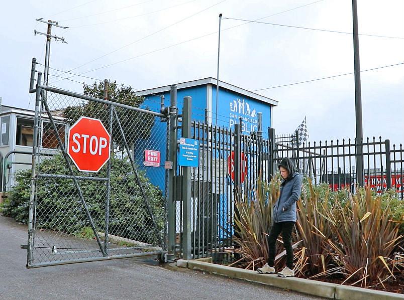 Heather Lee stands outside a closed gate at the Public Works yard after attempting to reclaim her belongings.