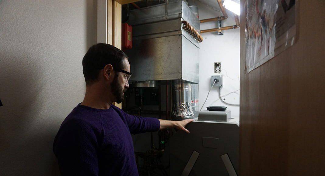 Aaron Cooke demonstrates a heat-recovery ventilator at his house in the sustainable house at the Cold Climate Housing Research C